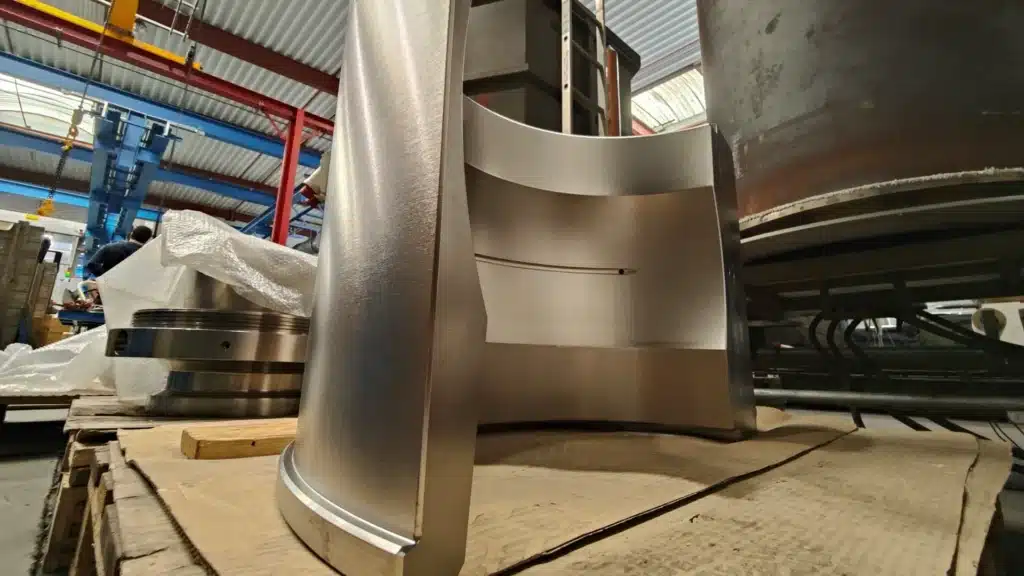 Substantial half-arch piece, undergoing electroless nickel plating followed by a hardening heat treatment. This sequence of processes aims to provide corrosion protection and strengthen the structure of the piece for optimal mechanical resistance. The piece is ready to face rigorous conditions after this combination of treatments.